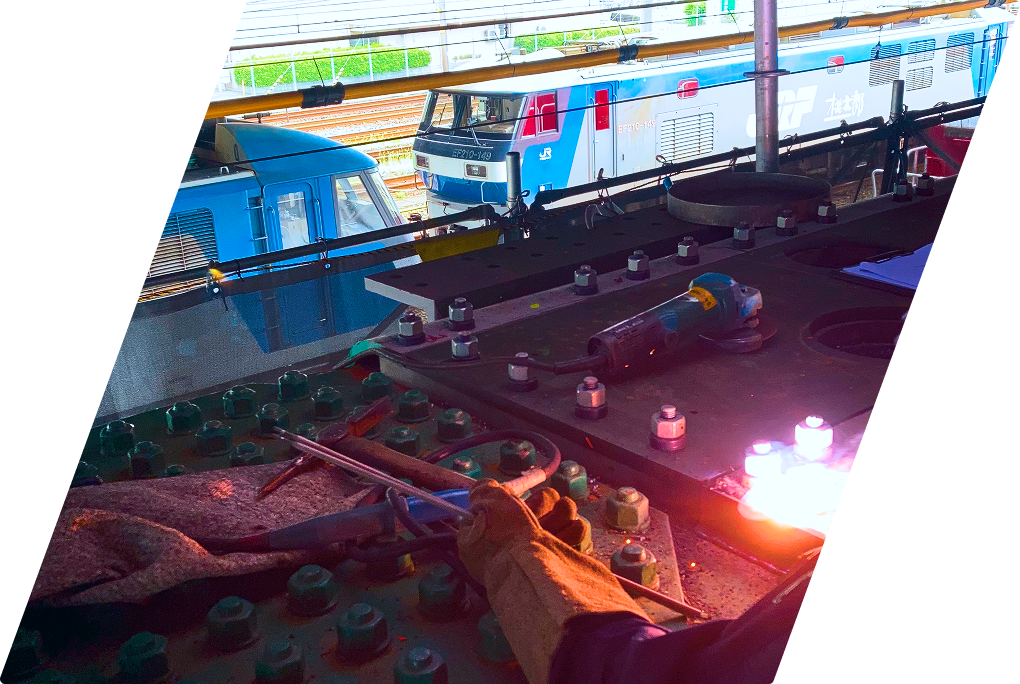 鉄道線路脇で鋼材のガス切断作業を行う現場