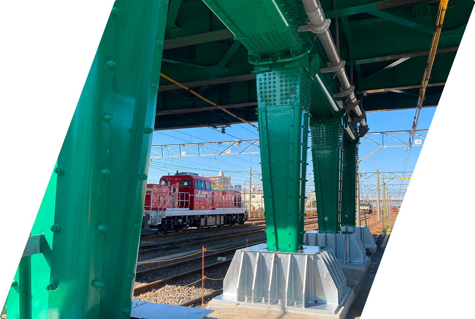 緑色のトラス橋梁の橋脚部分と耐震補強部材