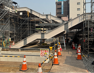 駅構内の仮設階段と足場が設置された鉄骨工事の現場