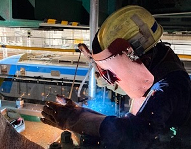 溶接面を装着し火花を散らしながら溶接を行う技術者