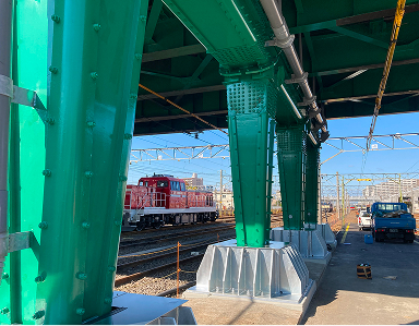 緑色のトラス橋梁の橋脚部分と耐震補強部材