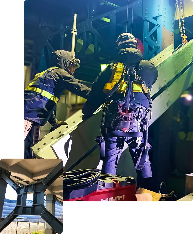 夜間の鉄道高架下で安全帯を装着し高所作業を行う技術者